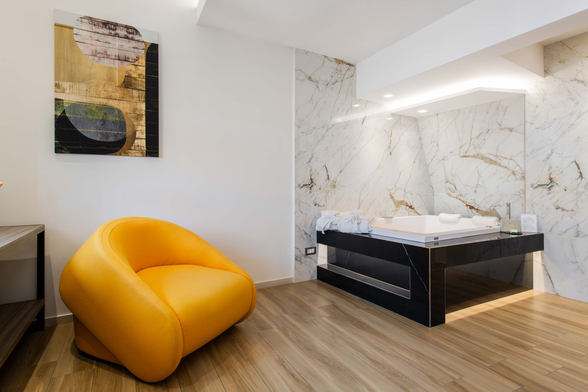 Junior Suite con vasca idromassaggio in marmo e poltrona gialla - Municipio Luxury Suite Napoli