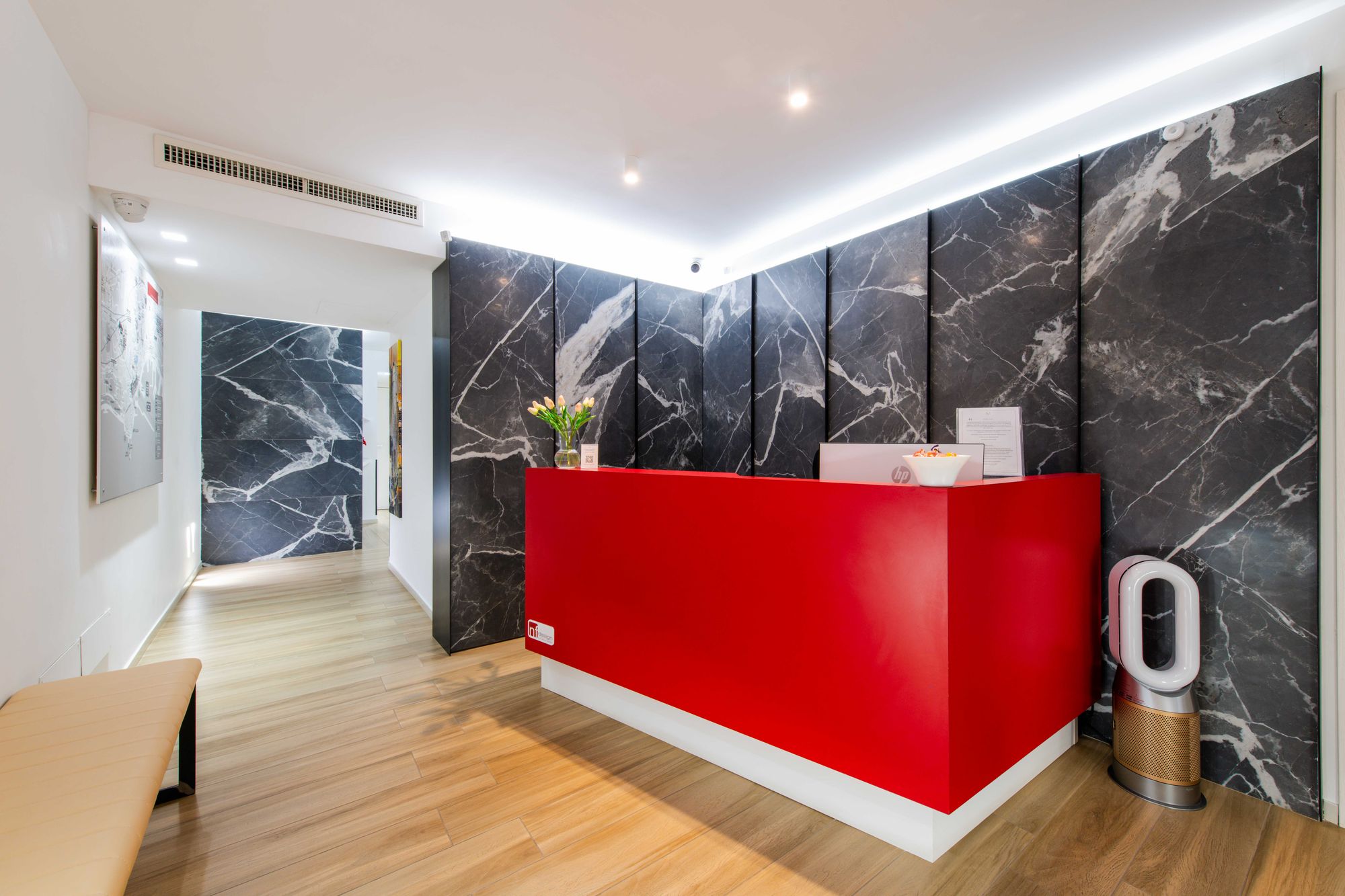 Reception con banco rosso e parete in marmo - Municipio Luxury Suite Napoli