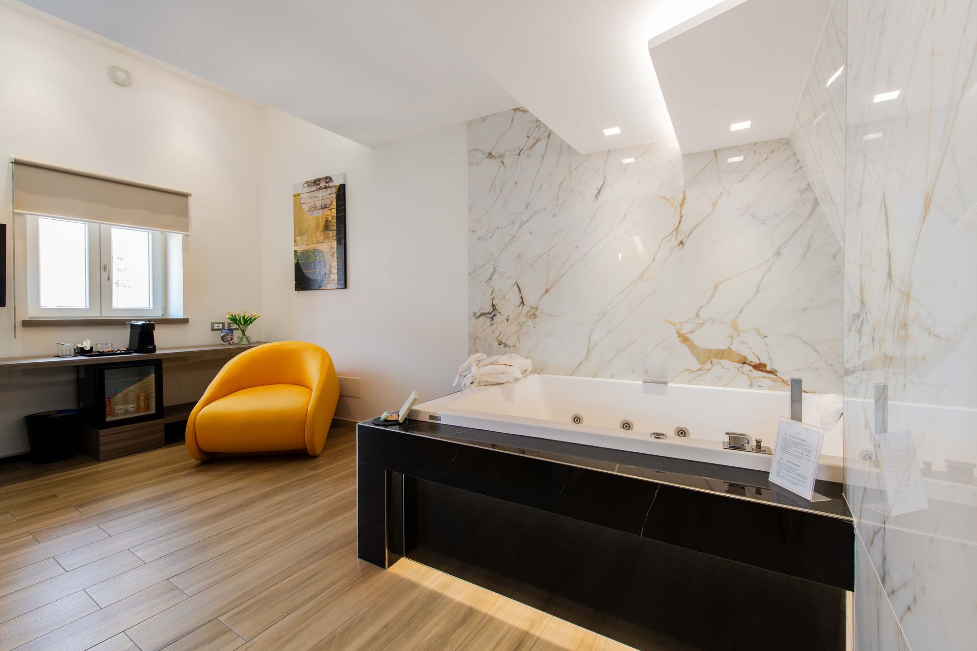 Angolo lettura della suite con vasca idromassaggio e poltrona gialla - Municipio Luxury Suite Napoli, foto 20