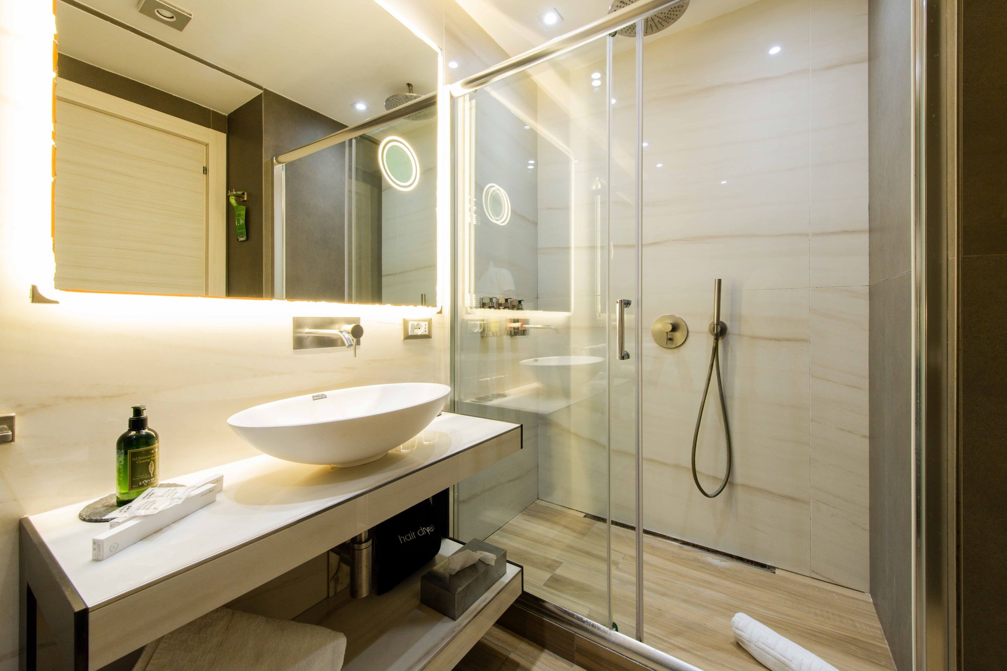 Bagno con doccia in vetro, specchio rotondo e lavabo moderno - Municipio Luxury Suite Napoli, foto 2