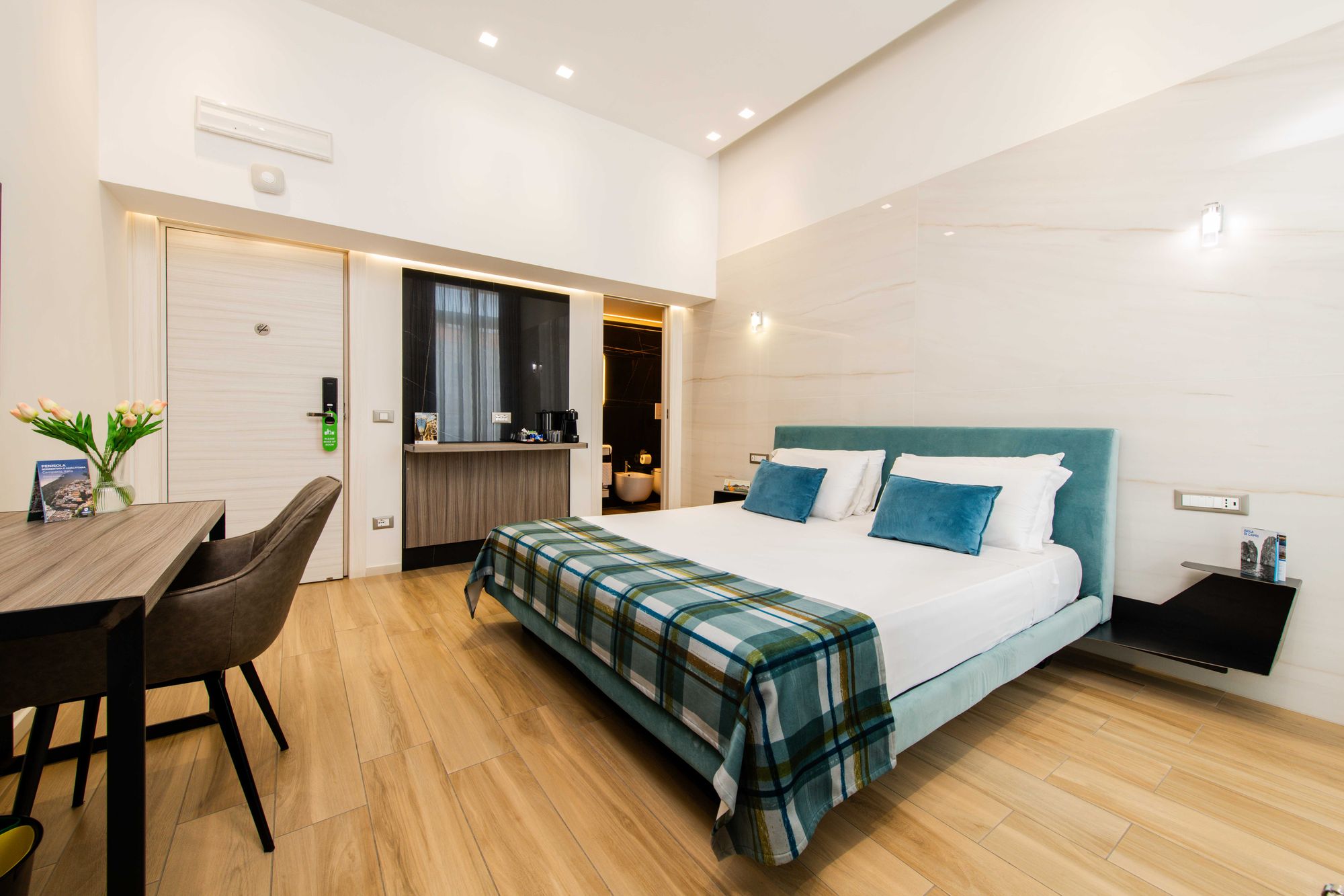 Camera con scrivania, poltroncina e letto con plaid a quadri, B&B Piazza Municipio Napoli