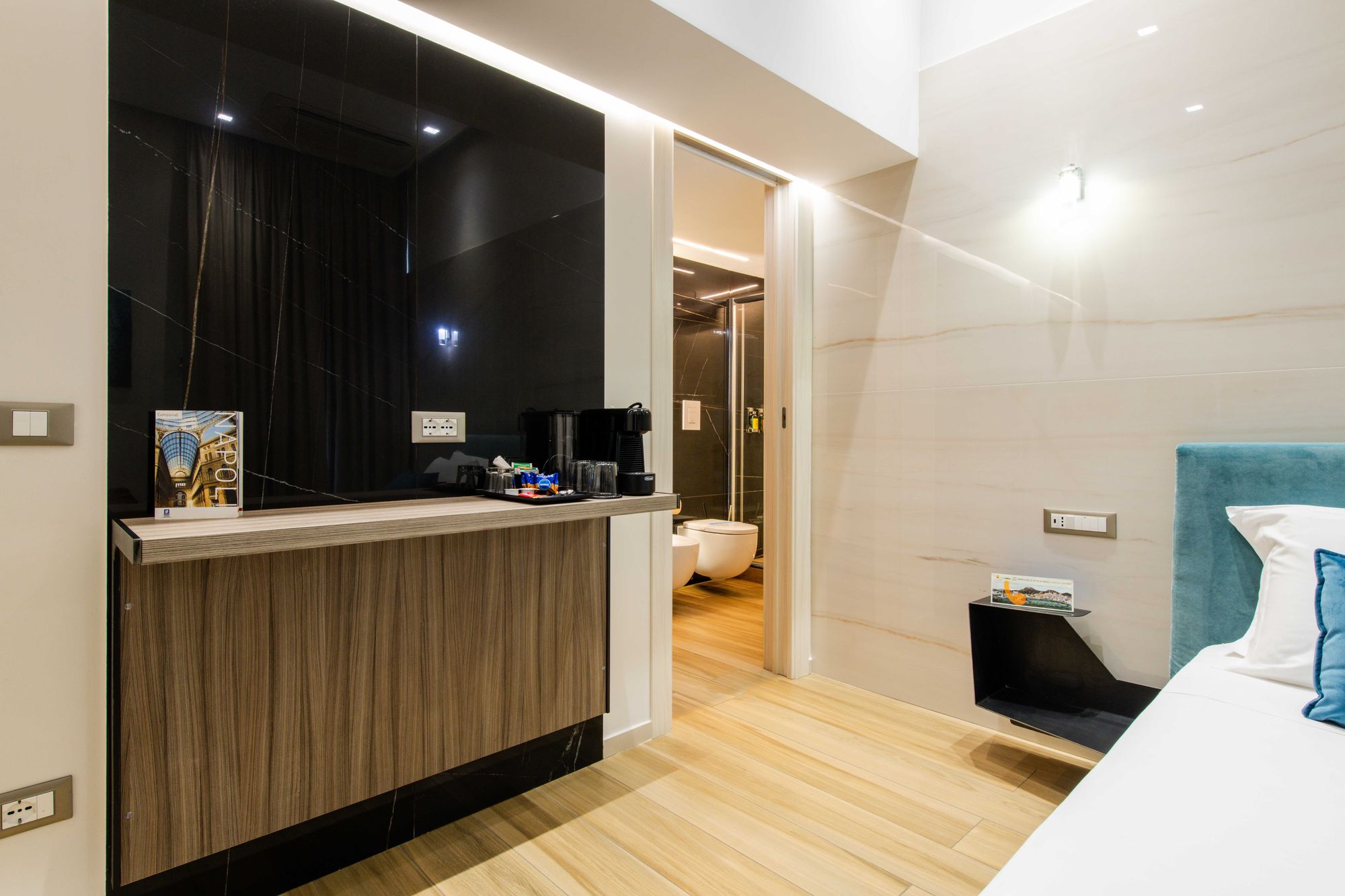 Ingresso della camera con TV a parete, angolo caffè e accesso al bagno, Napoli centro