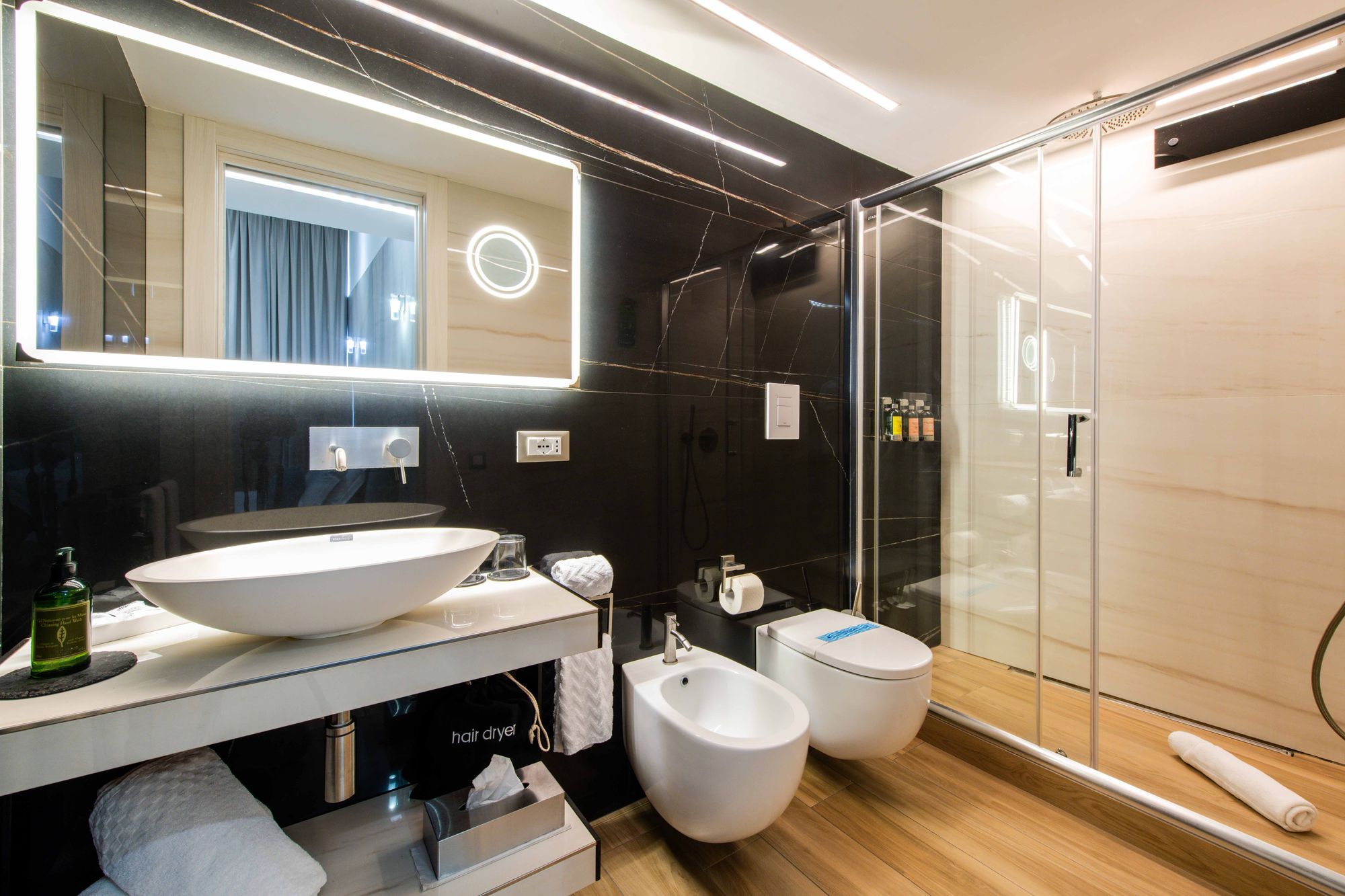 Bagno in marmo nero con lavabo, bidet e specchio illuminato, B&B Piazza Municipio Napoli