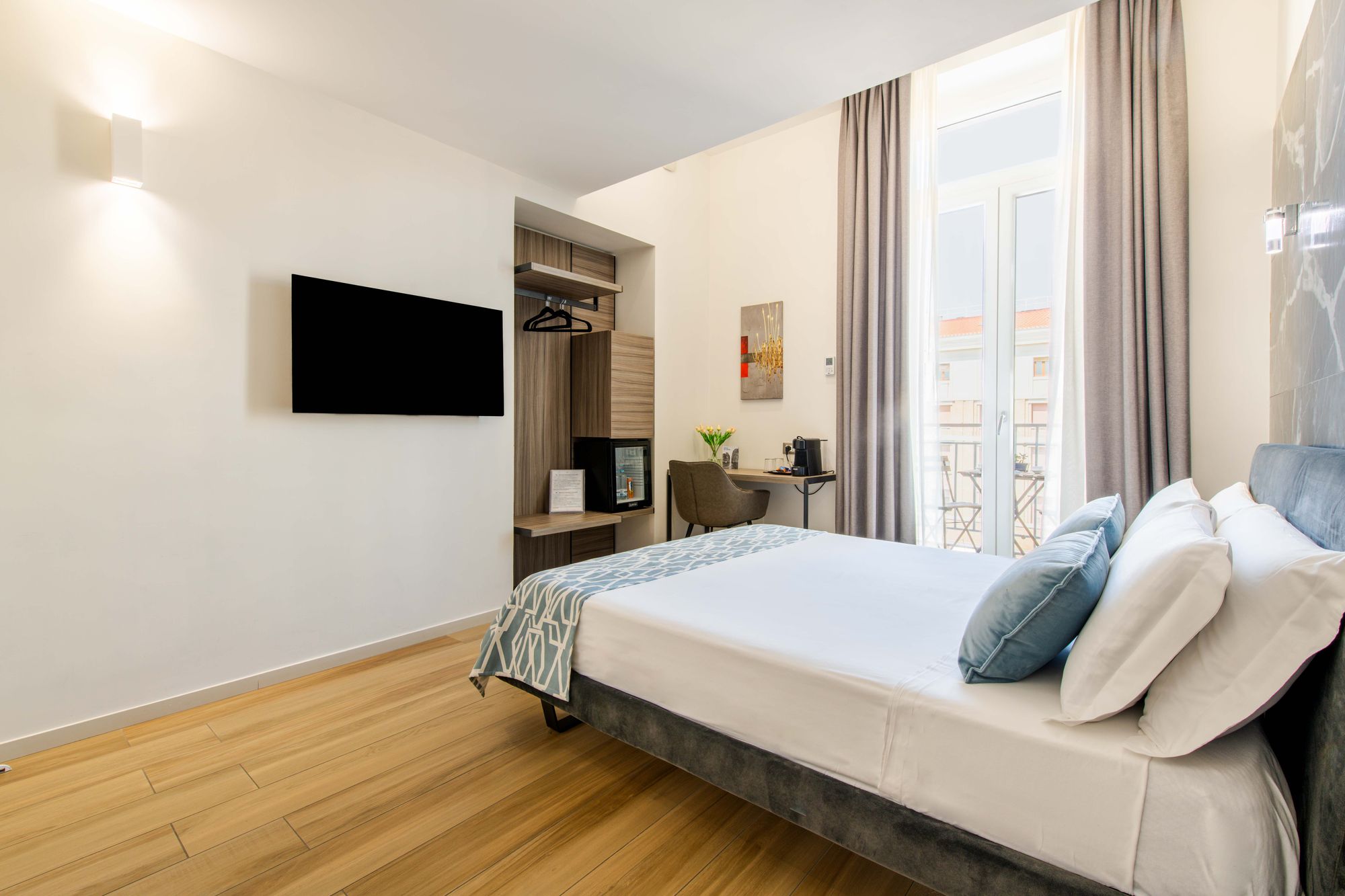 Zona ingresso con armadio, TV, poltroncina e angolo caffè con tulipani - Municipio Luxury Suite Napoli, foto 5