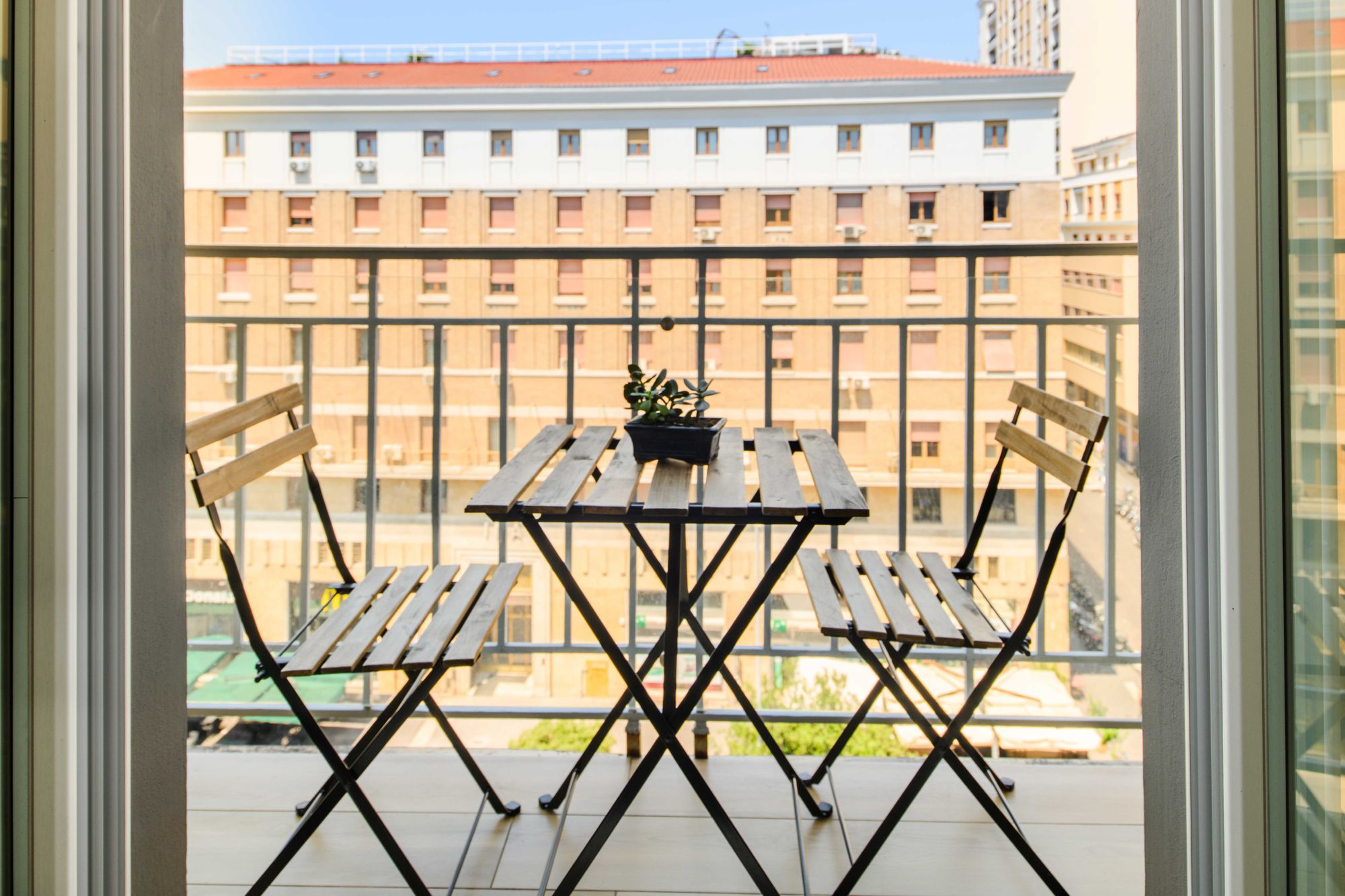 Balcone con tavolino e sedie in ferro, vista sugli edifici di Piazza Municipio Napoli