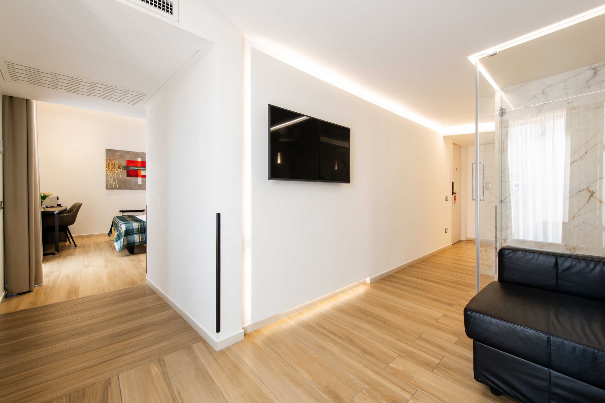Ingresso della suite con sauna, armadio e TV a parete, pavimento in parquet, Napoli centro