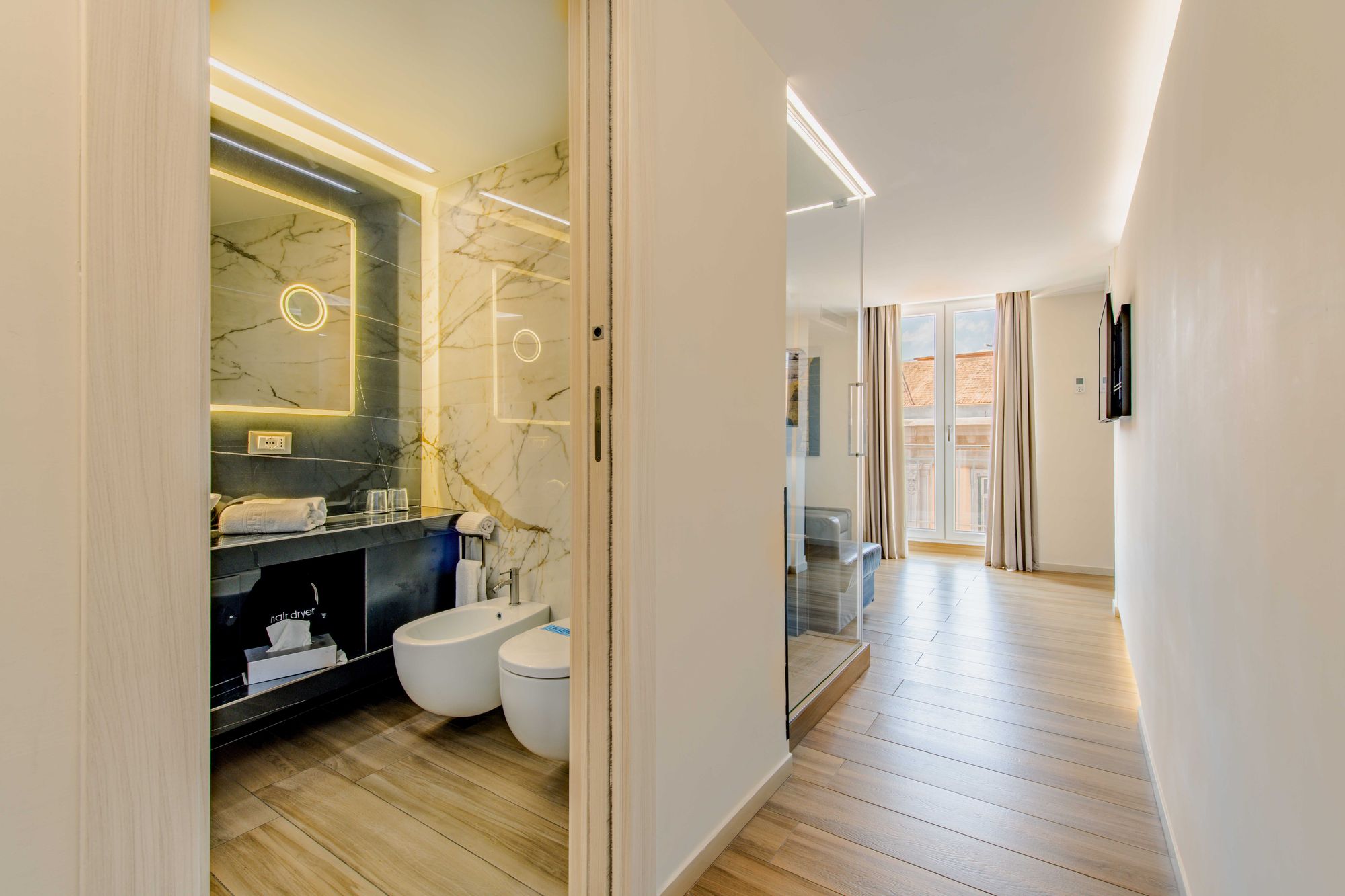 Bagno con specchio in marmo, bidet e vista sul corridoio della suite, Napoli centro
