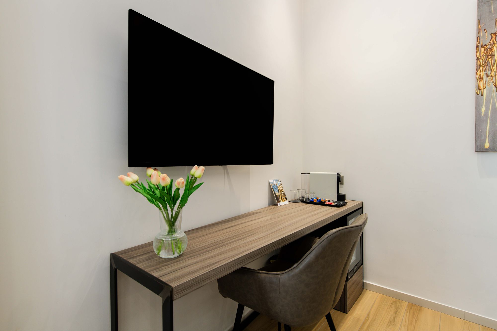 Scrivania con TV a parete e vaso di tulipani, suite con sauna B&B Piazza Municipio Napoli