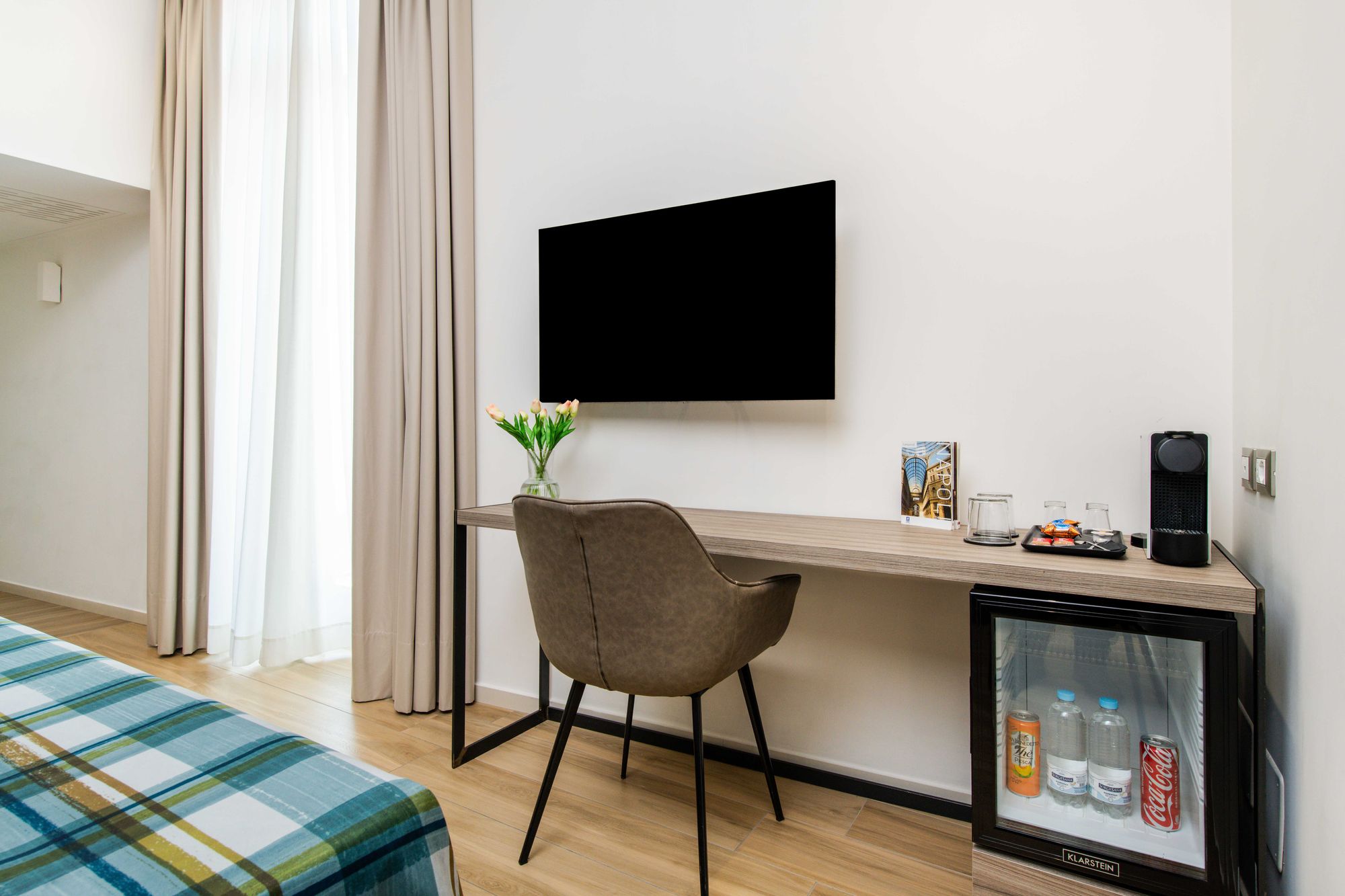 Scrivania con TV, poltroncina e plaid a righe sul letto e minibar, suite con sauna Napoli centro