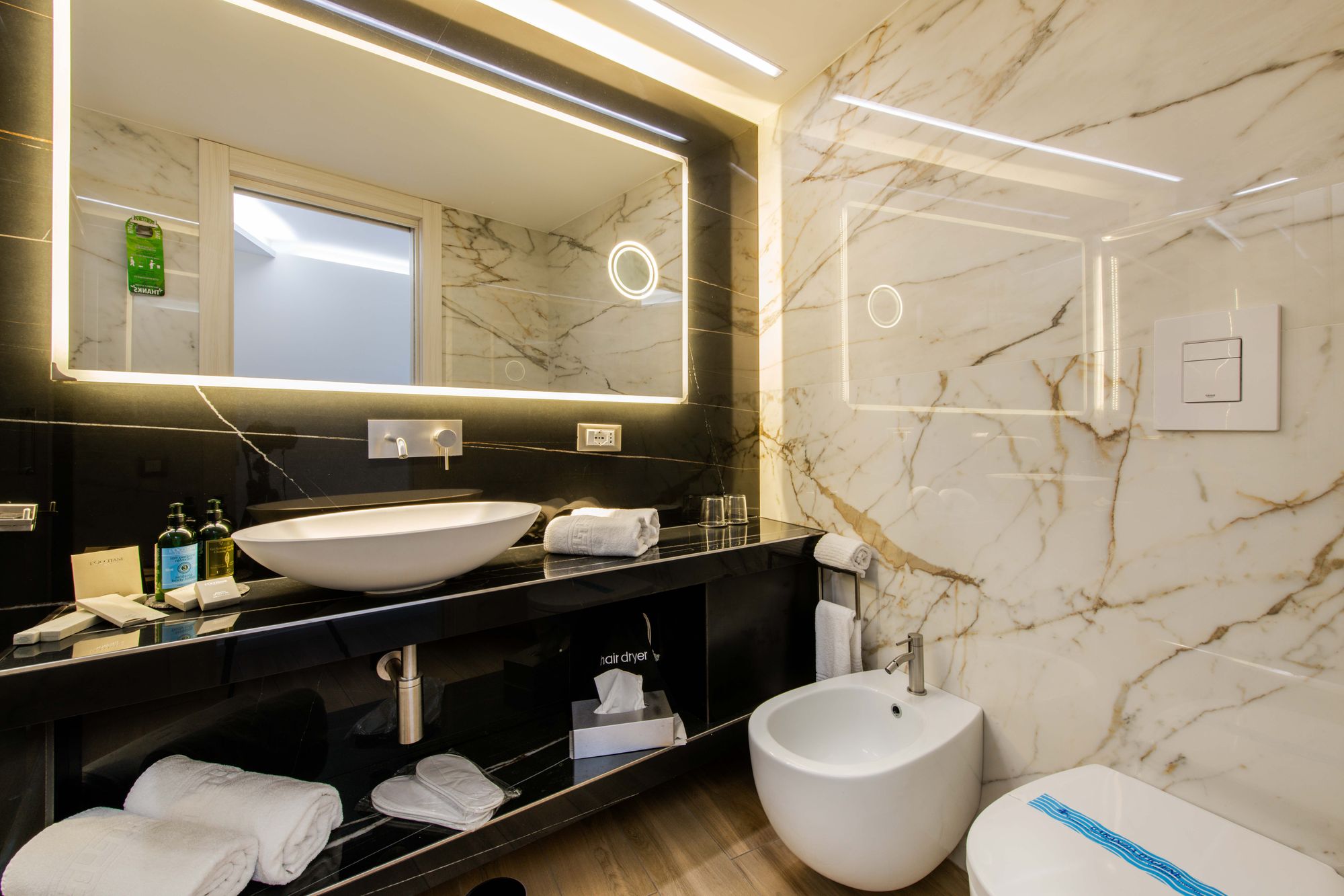 Lavabo in marmo nero con bidet e specchio illuminato, bagno suite Napoli centro