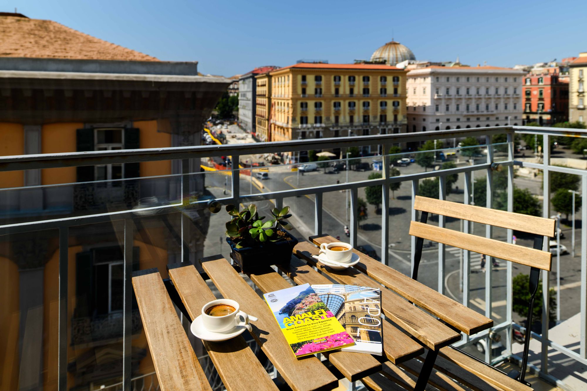 Balcone con tavolino, colazione e riviste, vista su Piazza Municipio Napoli