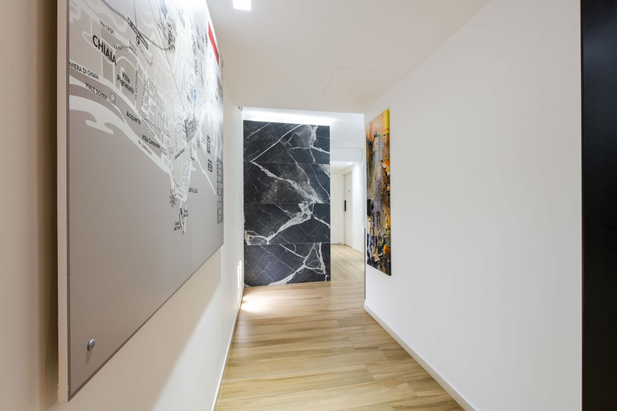 Dettaglio quadro con mappa e parete in marmo nel corridoio, B&B Piazza Municipio Napoli