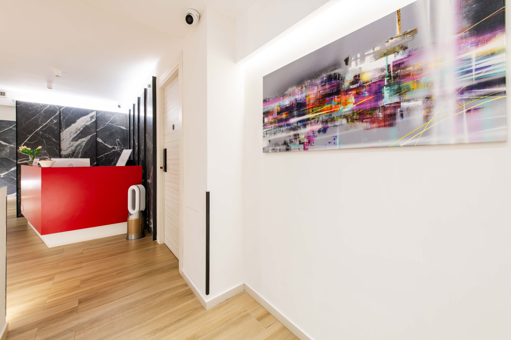Reception con banco rosso, parete in marmo e quadro astratto colorato, Napoli centro