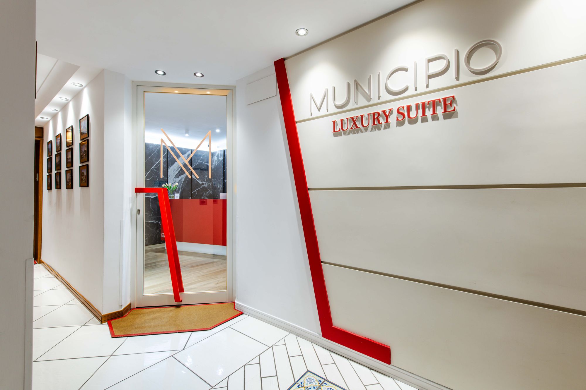 Corridoio d'ingresso con insegna Municipio Luxury Suite e parete rossa, B&B Napoli centro