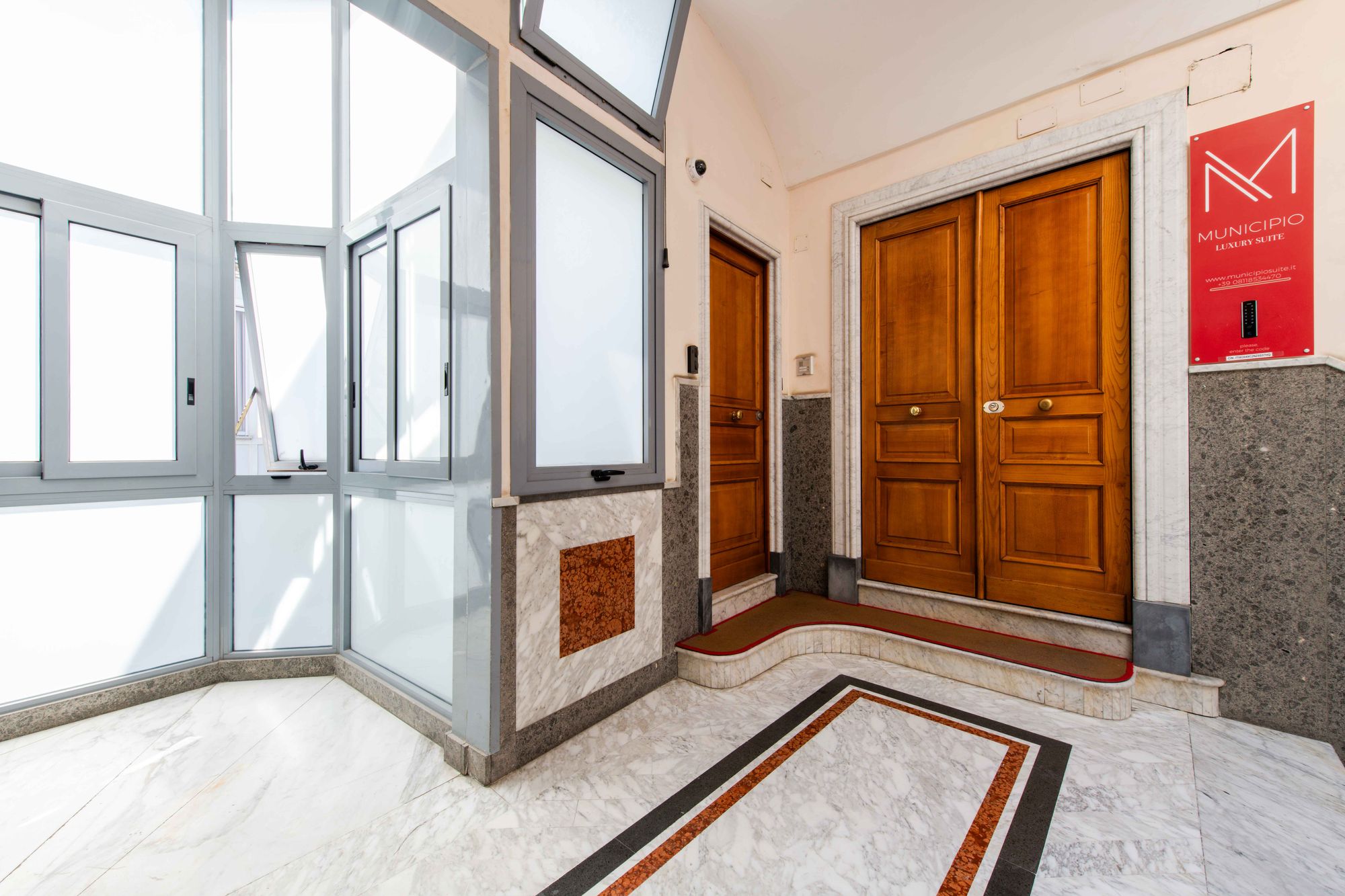 Vano scale con porte in legno e pavimento in marmo, Municipio Luxury Suite Piazza Municipio Napoli