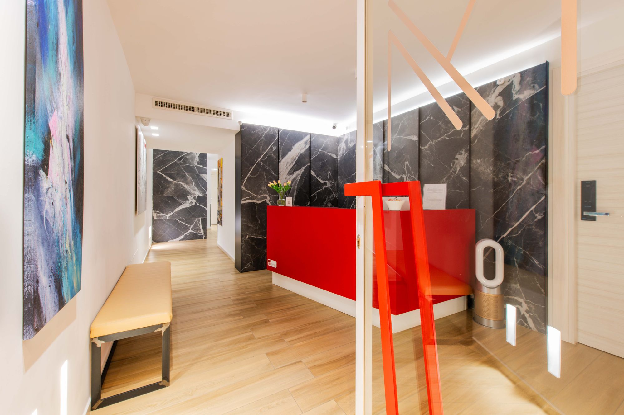 Dettaglio reception, parete in marmo e accenti rossi, B&B Municipio Luxury Suite Napoli